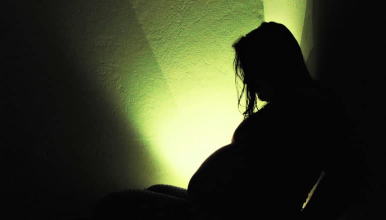light behind pregnant person in silhouette