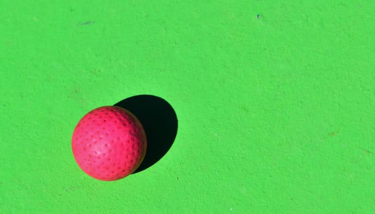 red golf ball on green background
