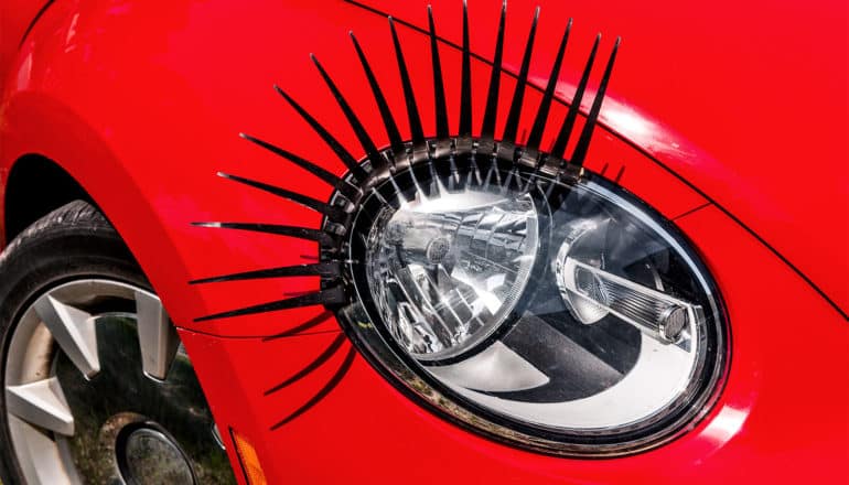A red car's headline has plastic eyelashes attached