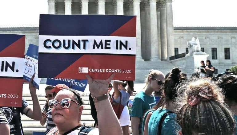 Protestors outside the US Supreme Court hold up signs that read "Count Me In"