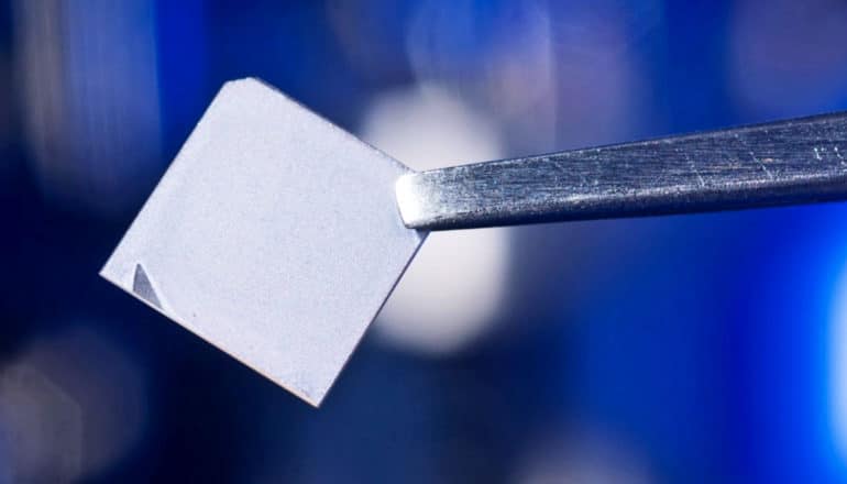 A pair of tweezers holds a small square of the new film.