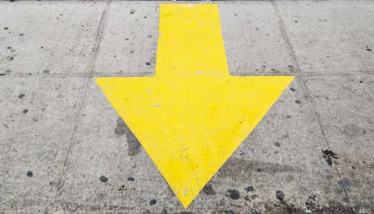 A yellow arrow points down as if to say "here" on some gray concrete