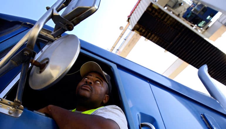 trucker looks up as container gets loaded