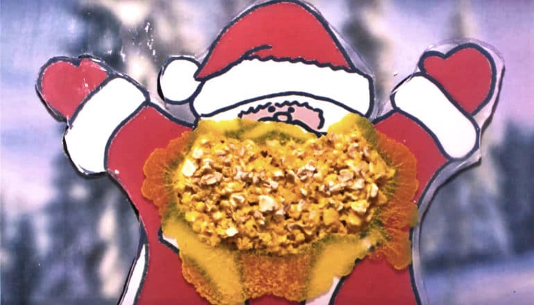 The yellow slime beard grows on a plastic-looking Santa cut out