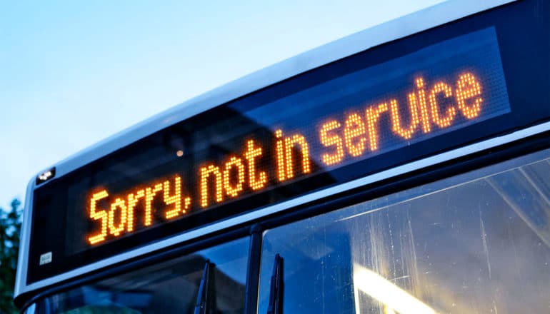 A bus has a "sorry, not in service" sign above its windshield in lights
