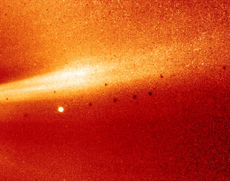 The grainy image shows a bright orange streamer against a dark orange background