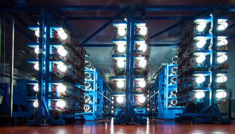 rows of lights and wires on racks in dark room