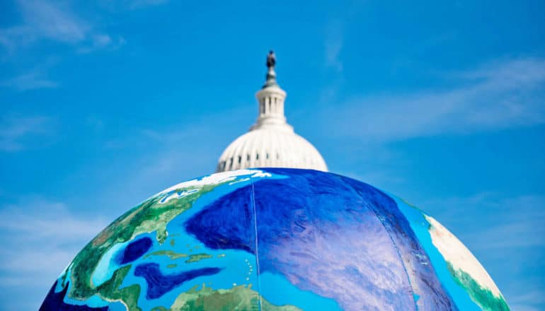 dome of Capitol building above top of inflatable globe