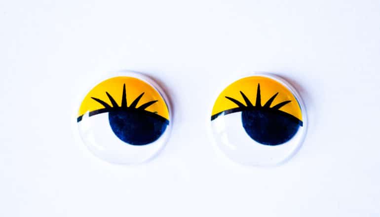 two googly eyes with yellow lids and lashes look to the right