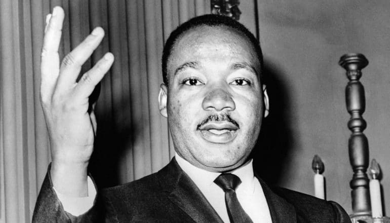 Dr Martin Luther King with hand raised while speaking