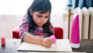 child plays with paints at table