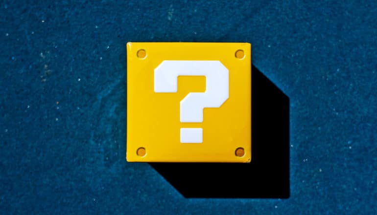 A yellow block with a question mark on it sits on a dark blue background
