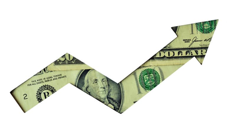 $100 bill behind arrow-shaped cut-out in white paper