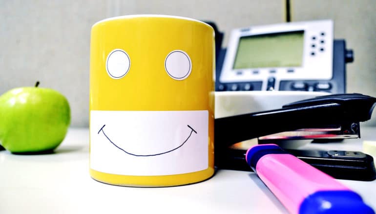 mug with stick-on eyes on messy desk