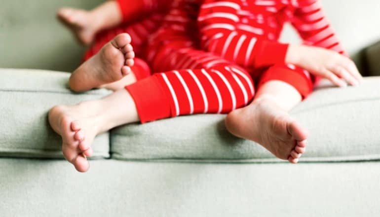 feet of two kids in red PJs on couch