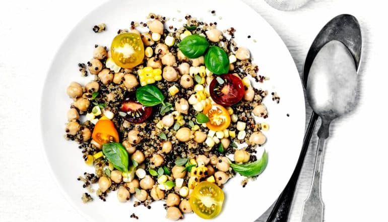 quinoa, chickpeas, tomatoes, and basil on plate with spoons