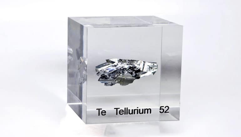 metallic shard encased in clear material labelled "Te Tellurium 52"