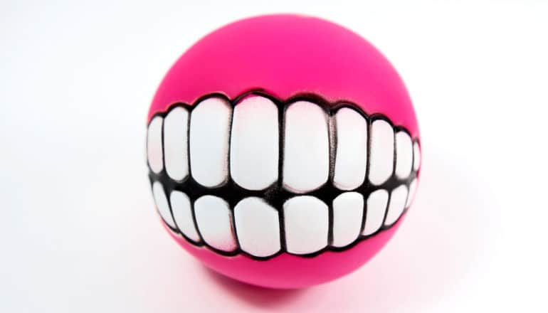 A pink ball has white teeth draw on it