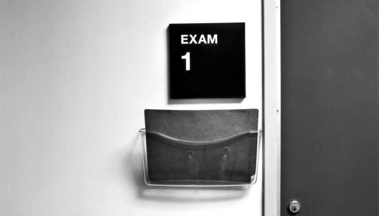 A sign outside an examination room at a doctor's office reads "Exam 1"
