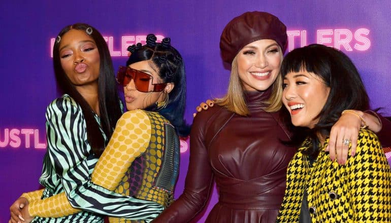 Keke Palmer, Cardi B embrace, make kissy faces next to J Lo with arm around Constant Wu. Step & repeat behind them says "Hustlers"