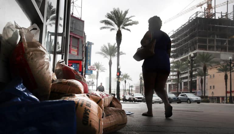 person in silhouette walks by sandbags in New Orleans