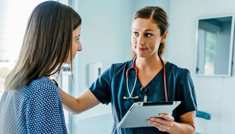 medical professional talks with female patient