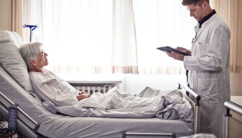 doctor talks to patient in hospital bed