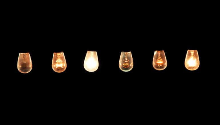A row of lights at different dimnesses sit against a black background