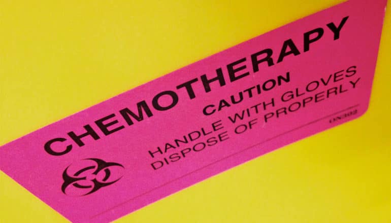 A pink sticker on a yellow background reads "Chemotherapy. Caution. Handle with gloves and dispose of properly"