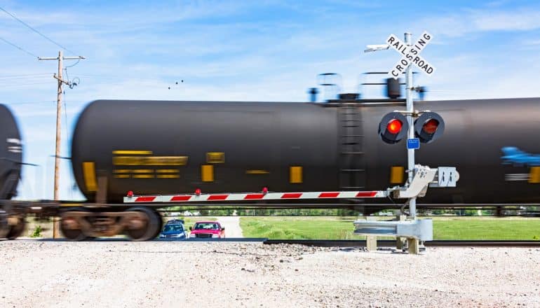 train tank car speeds through intersection with red light and bar