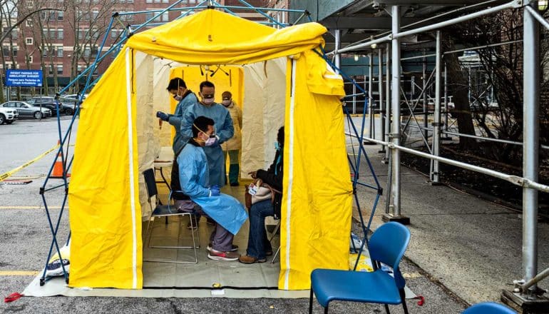 yellow tent in which medical workers test patient