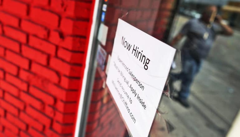 "now hiring" sign on window