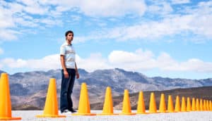one person stands behind road cones in front of mountain vista
