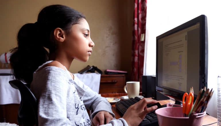 teen uses computer at home desk