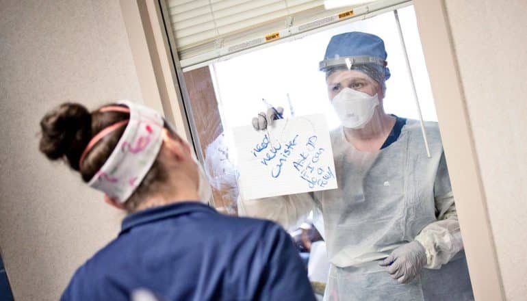 nurse reads coworker's note through hospital room window