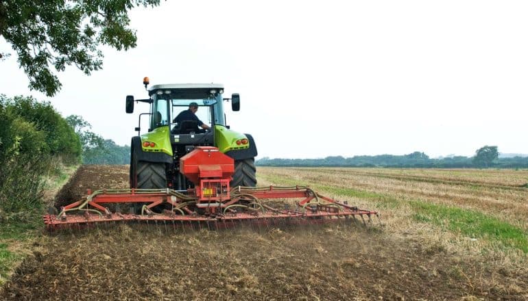 A farmer drives a tractor over a field