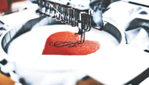 An embroidery machine stitches a heart