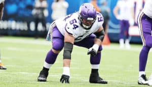 A lineman in his starting stance has his hand on the ground and his head down