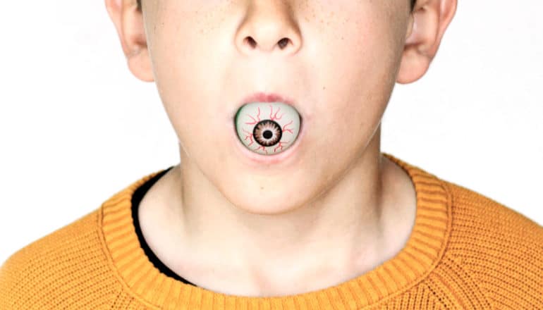 person with toy eyeball in mouth