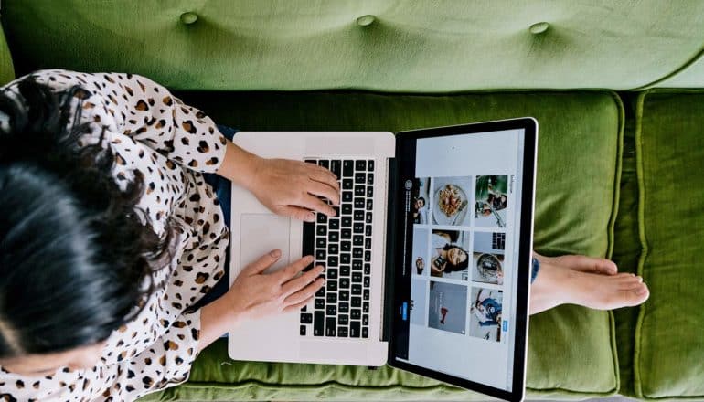 from above, barefoot person uses laptop on couch