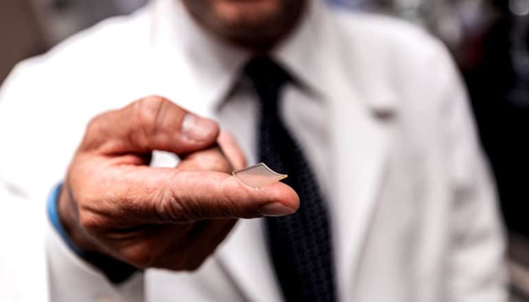 clear patch on fingertip of unrecognizable person in lab coat and tie