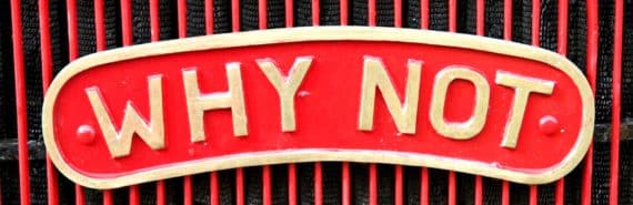 red sign with plaque reading "WHY NOT"
