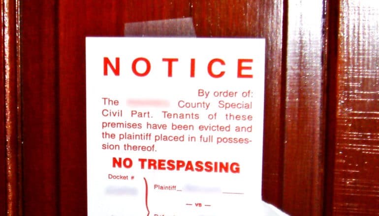 An eviction notice taped to a red door