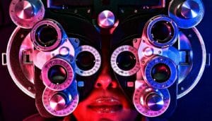 A woman looks through a vision test apparatus