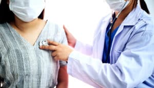 A doctor listens to to a patient's heart