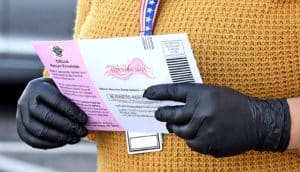 gloved hands hold ballot