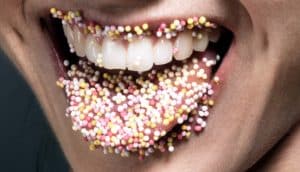 round sprinkles on lips and tongue