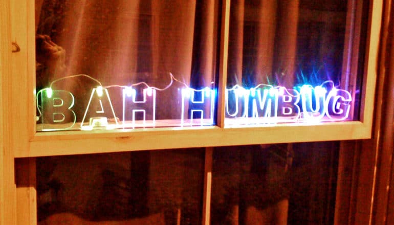 Christmas lights on a windowsill read "Bah Humbug"
