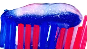 Toothpaste on a blue and pink toothbrush