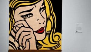 A painting shows a woman crying, either in sadness or joy